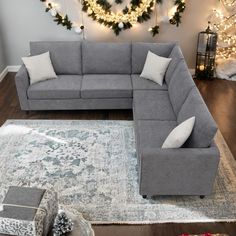 a living room filled with furniture next to a christmas tree and wreaths on the wall