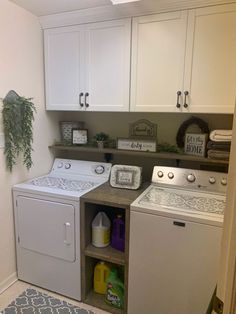 a washer and dryer in a small room with white cupboards on the wall