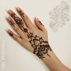 a woman's hand with henna tattoos on it