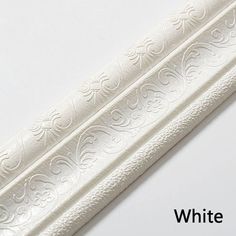 white embossed paper on a white background with the words white written below it