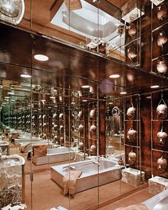 a bathroom with mirrored walls and lots of bathtubs in the shower area is shown