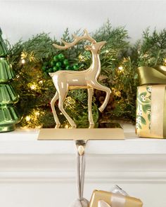 a gold deer figurine sitting on top of a mantle next to christmas presents