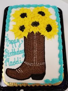 a birthday cake with a boot and sunflowers on it