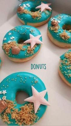 six donuts with blue icing and starfish decorations