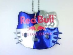 a red bull key chain with a blue and white cat on it's face