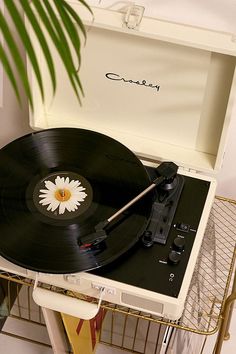 a record player sitting on top of a table next to a plant