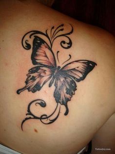 a butterfly tattoo on the back of a woman's shoulder