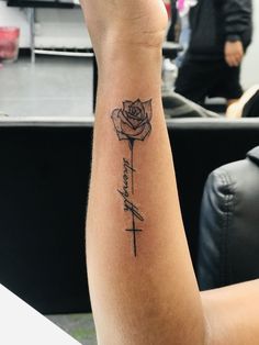 a woman's arm with a tattoo on it that says faith and a rose