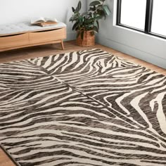 a zebra print rug in a living room with a plant on the floor and a window behind it