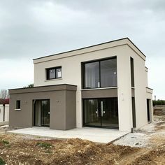 a house is being built on the side of a dirt field with no grass in front of it