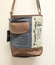 This  Myra Bag, is a unique and eco-friendly product that embodies peace and patience. Crafted from upcycled canvas and leather, this bag is not only stylish but also sustainable. Each bag is carefully handcrafted, ensuring its durability and quality. With its spacious interior and multiple compartments, it offers ample storage for your essentials. The combination of canvas and leather gives it a rustic yet sophisticated look, making it a versatile accessory for any occasion.  Measures: Height 1 Upcycled Canvas Shoulder Bag For Daily Use, Daily Use Upcycled Satchel Shoulder Bag, Eco-friendly Upcycled Canvas Bag, Casual Upcycled Canvas Bag For Daily Use, Upcycled Canvas Bag For Everyday Use, Eco-friendly Upcycled Shoulder Bag For Everyday Use, Upcycled Everyday Canvas Bag, Upcycled Canvas Satchel Shoulder Bag, Casual Canvas Bags With Upcycled Details