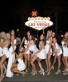 a group of women posing in front of the las vegas sign