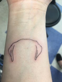 a person's wrist with a small tattoo of a dog on the left arm