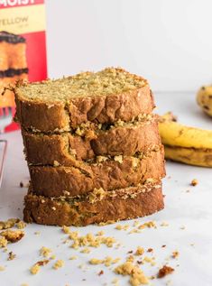 three slices of banana bread stacked on top of each other next to a box of brownies