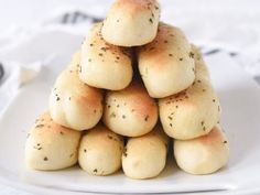 a pile of rolls sitting on top of a white plate