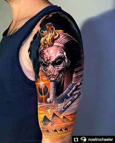 a man with a tattoo on his arm that has an image of a skeleton and pyramids