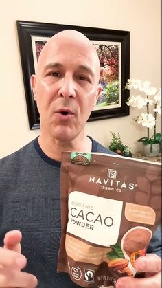 a man holding up a bag of cacao powder