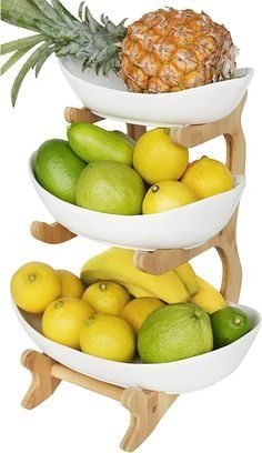 three white bowls filled with fruit sitting on top of each other in front of a pineapple