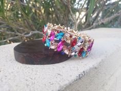 "Beautiful bracelet with large multi color marquise crystals, great statement piece! Pageant, prom, or bridal! Size: 1.5\" wide Style: stretch bracelet color: fuchsia/yellow/ emerald green/ purple/ aqua, multi colors Base metal color: gold Looking for matching earrings? Browse through our listings or send us a message! :) https://www.etsy.com/listing/538912077/fuschia-large-crystal-earrings?ref=shop_home_active_21&crt=1 https://www.etsy.com/listing/623725360/multi-color-earrings-multi-color? Prom Bracelet, Valentines Bracelets, Multicolor Earrings, Color Earrings, Rainbow Bracelet, Large Crystal, Color Rainbow, Color Fuchsia, Bridal Bracelet