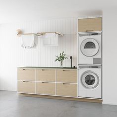 a washer and dryer sitting in a room next to each other on top of cabinets