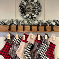 christmas stockings hanging from a mantel in front of a wreath