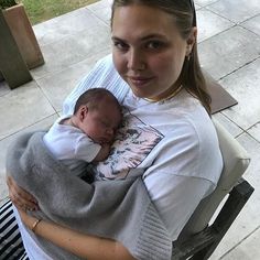 a woman holding a baby wrapped in a blanket