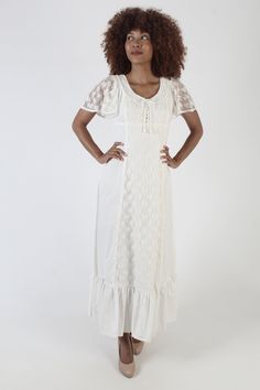 This is a charming cottagecore prairie dress from the 1970s.  It has a tailored empire bodice with corset tie chest and lace flutter sleeves. The dress is fitted at the waist and has a draped and tiered skirt. Made of a soft cotton material with floral lace overlay. Dress zips up the back. The dress is in great pre-owned vintage condition. Please review the detailed measurements below for an accurate fit.  size estimate: M shoulders: 15" bust: 38" waist: 31" hips: 58" total length: 54.5" Model is 5'9" and measures 33" bust, 26" waist, 37" hips. Belts/accessories are not included unless noted in the description Sheer Sleeve Wedding Dress, Sleeve Wedding Dress Lace, Outfit Short, Country Style Outfits, Lace Wedding Dress With Sleeves, Lace Up Corset, Wedding Dress Lace, Corset Bodice, Sleeve Wedding Dress