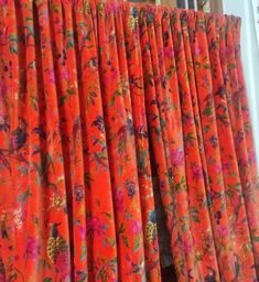 an orange curtain with pink flowers on it