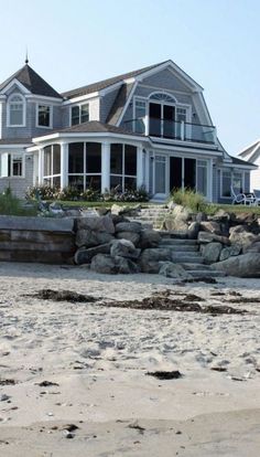 a large house sitting on top of a sandy beach