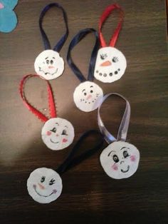 four snowman headbands with faces on them and one has a red ribbon