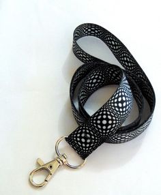 "GEOMETRIC BUBBLES detailed black and white print neck strap lanyard (non-detachable clasp, 20mm width) From our range of unique neck strap lanyards. High quality UK printed ID holder lanyards, printed on both sides, fitted with a metal clip, to be worn around the neck to carry ID, access cards, keys etc. Product code : H-323 Hand made in the UK Size: 94cms (36\") Width : 20mm (0.8\") Silver metal clip *  Great quality and value *  Beautifully coloured, bright vivid sublimation print *  Lightweight *  Smooth polyester fabric remains comfortable to wear *  Long lasting metal trigger clip UK manufacturer and seller All prices include free UK post & packing All lanyards are individually packed Available in 3 options: Standard lanyard with just a metal hook Safety breakaway lanyard with metal Black Lanyard With Lobster Clasp As Gift, Black Lanyard With Key Leash As Gift, Personalized Lanyards, Custom Lanyards, Key Lanyard, Black And White Print, Metal Hooks, Id Holder, Neck Strap