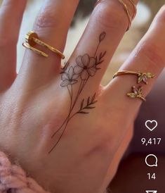 two fingers with tattoos on them and flowers