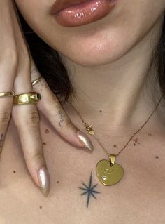 a close up of a person with tattoos on her chest and two rings around their neck