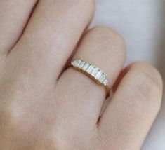 a woman's hand with a gold ring on top of her finger and the band is