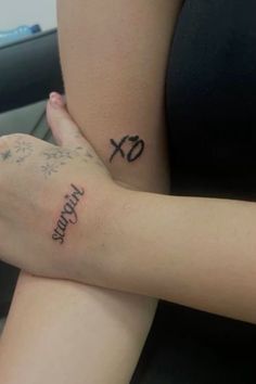 two people with tattoos on their arms sitting next to each other