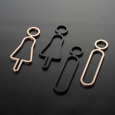 three pieces of metal on a table with scissors and paper clips in the shape of people