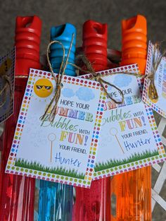 colorful toothbrushes with tags attached to them sitting in a holder on the ground