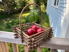 two apples are in a basket on the porch