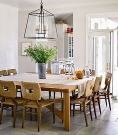 a dining room table with chairs and a potted plant