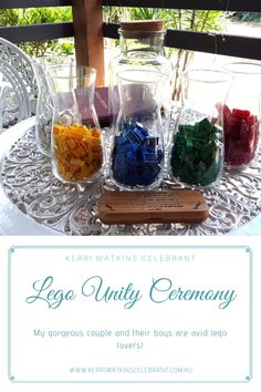 four vases filled with different colored rocks on top of a table