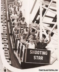 an old black and white photo of people on a roller coaster holding up their hands