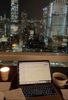 an open laptop computer sitting on top of a desk next to a cup of coffee