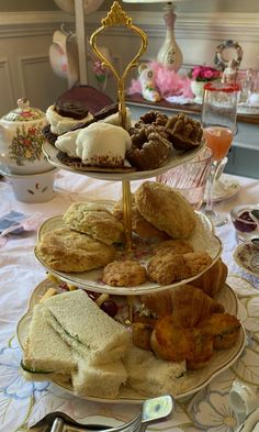 three tiered trays filled with different types of pastries and desserts on a table