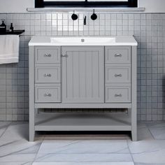 a white sink sitting under a window in a bathroom