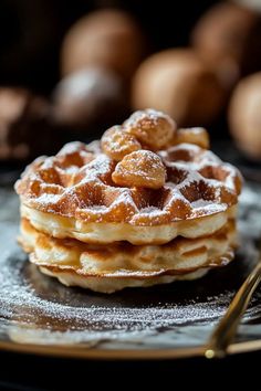 a stack of waffles with powdered sugar on top