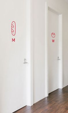 three white doors with red stickers on them in a room that has wood floors and hard wood flooring