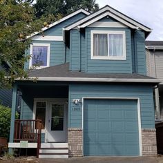 a blue two story house with white trim