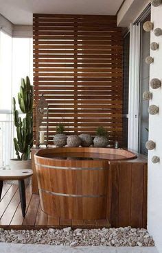 a wooden tub sitting on top of a wooden floor next to a window covered in succulents