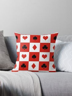 a red and white checkerboard pattern with black hearts on the back throw pillow