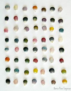 several different colored drops of water on a white surface